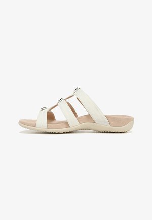 White slide sandals with three narrow straps, textured surface, cushioned footbed, and a durable beige outsole with grip patterns.