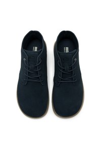 Scarpe in suede blu navy con punta arrotondata, dotate di lacci e suola in gomma beige. Il logo del marchio è impresso sulla linguetta.