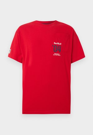 Punane lühikeste varrukatega T-särk rinnataskuga ja väikese trükiga, millel vasakul ees kirjas "Red Bull '04 Precision on the Track".