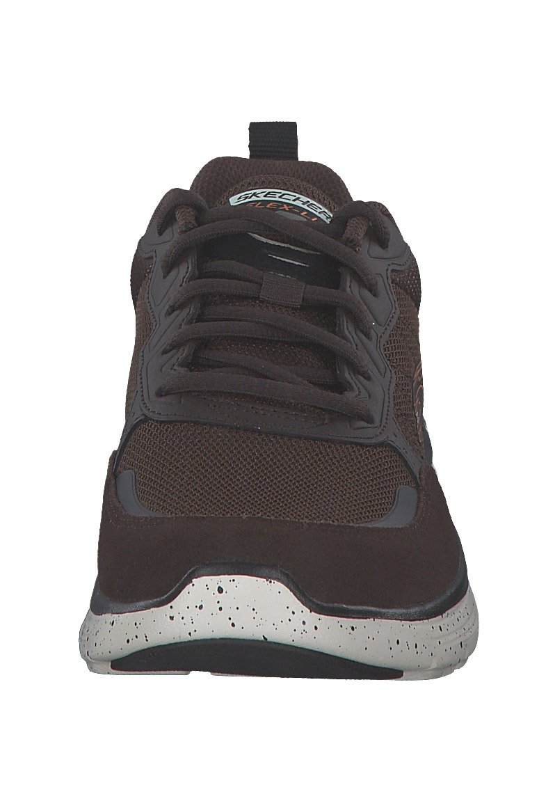 Zapato deportivo marrón con parte superior de malla y ante, puntera redonda, diseño con cordones, mediasuela moteada en gris y detalle del logo en la lengüeta.