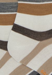 Calzini a righe in tonalità terrose di marrone, beige, grigio e crema. Materiale morbido in misto cotone con punta e tallone rinforzati per maggiore durabilità.