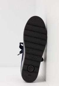 Zapato de marinero con suela de goma texturizada, que presenta finas ranuras y un acento claro en contraste a lo largo del borde; marcado con "Gabor."