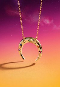 Collar con forma de media luna dorada adornada con coloridas piedras preciosas en forma de estrella a lo largo de la curva, colgado de una delicada cadena dorada, sobre un fondo degradado.