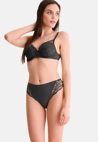 Zwarte kant bh met gevormde cups en decoratieve bandjes, gecombineerd met bijpassende high-waisted slipjes die kantaccenten aan de zijkanten hebben.