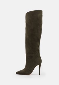Bota alta de tacón en ante verde oscuro, con puntera puntiaguda y silueta ajustada. Textura suave con costuras mínimas.