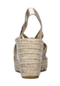 Sandali wedge espadrille beige con tacco in juta intrecciata, cinturini metallici e una cinghia alla caviglia posteriore. Design testurizzato e apertura sul retro.