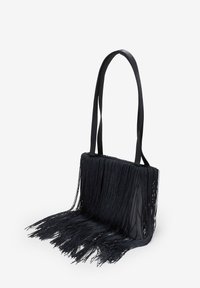 Bolso de mano negro con flecos, de forma rectangular, con flecos largos que se extienden desde la parte inferior y dos asas planas para los hombros. Tejido texturizado.