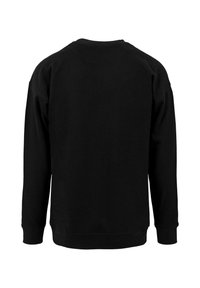 Must kollane särk ümarate kaelustega, pikkade varrukatega ja soonikkoes mansettidega. Sile tekstuur, lihtne disain, nähtavate logode või mustriteta.