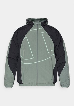 Pūkinis švarkas, turintis juodai pilką spalvų schemą, su ryškiu šviesiai žaliu kreivų raštų akcentu. Yra aukšta apykaklė ir užtrauktukas.