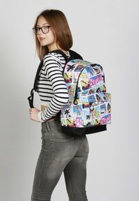 Mochila con un estampado de cómic colorido que presenta ilustraciones de Barbie, base negra, correas ajustables para los hombros y un bolsillo en la parte frontal.