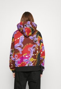Hoodie met een levendig kleurrijk patroon van gouden kettingen en bloemmotieven op een donkere achtergrond. Gemaakt van een katoenmix.