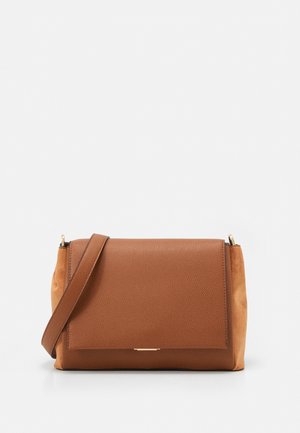 Bruine leren crossbodytas met een gestructureerde voorklep en bijpassende suède zijkanten tegen een witte achtergrond.
