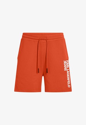 Punaiset puuvillasekoiteshortsit, joissa säädettävä kiristysnyöri vyötäröllä ja vasemmassa lahkeessa pystysuuntainen valkoinen teksti: "KARL LAGERFELD JEANS".