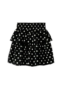 Svart prickig kjol med elastisk midja, som har två volanglager och ett texturerat tyg för ökad visuell intresse.