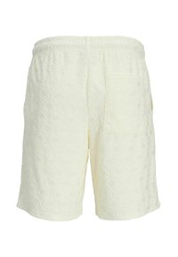 Pantalones cortos blancos texturizados con un patrón de concha, cinturilla elástica y un bolsillo trasero para mayor funcionalidad.