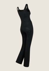 Black jumpsuit with a fitted bodice and flared legs, made from stretchy fabric. Features a back pocket and minimal strap design.