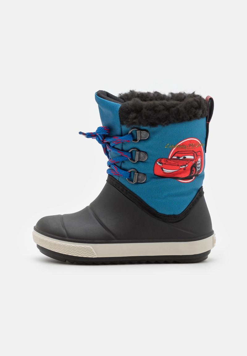Botte d'hiver pour enfants avec partie inférieure en caoutchouc noir, partie supérieure en tissu bleu, doublure en fourrure noire, lacets rouges et bleus, et motif de voiture rouge sur le côté.