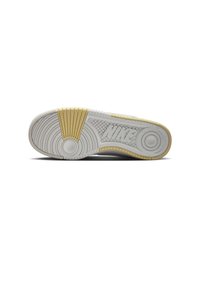 Suela de zapatilla Nike en blanco con un patrón texturizado. Presenta un acento amarillo en el talón y un logo en relieve. Material de goma.