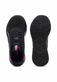 Adidași Puma cu un superior textil negru, accente roz și o talpă din cauciuc texturată, având un model zimțat pentru aderență.