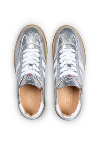 Baskets argentées avec une tige texturée, des lacets blancs et des accents à rayures blanches. Comprend une semelle intérieure beige et une semelle extérieure en caoutchouc naturel.