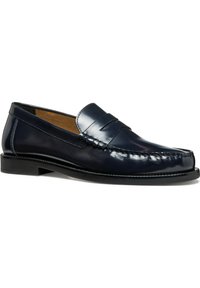 Mocassini in pelle blu navy con design cucito, texture liscia e suola bassa in gomma nera. Presentano una fascetta decorativa sulla parte superiore.
