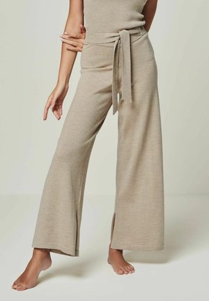 Beige weitbeinige Hosen aus strukturiertem Strick, mit einem gebundenen Gürtel an der Taille und seitlichen Schlitzen am Saum. Weiches, fließendes Material.