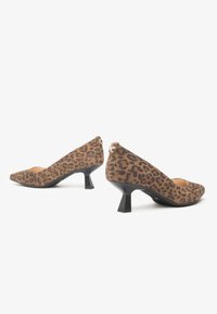 Scarpe con tacco a punta in stampa leopardata, realizzate in materiale morbido, caratterizzate da un tacco basso e spesso di colore nero e delicate rifiniture dorate.