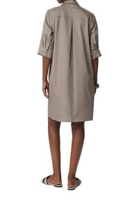 Hemdkleid in hellem Beige, gefertigt aus einem weichen Stoff, mit einem geknöpften Kragen, Dreiviertelärmeln und einem Rückenfalten für mehr Bewegungsfreiheit.