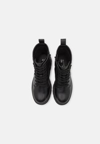 Sorte lær ankle boots med en glat overflade, der har snørebånd, en sidelukning med lynlås og en trækflap ved hælen for nem påtagning.