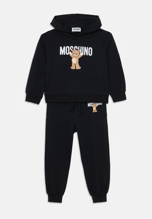 Čierna bavlnená mikina a tepláky so štýlovým grafickým motívom medveďa a bielym logom "Moschino". Hladké manžety a pás pre lepšie prispôsobenie.