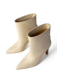 Beige nahkasaapad, millel on terav nina, lõtva ülemise osa ja madal plokk-konts. Omavad puhtaid jooni ja sujuvat tekstuuri.