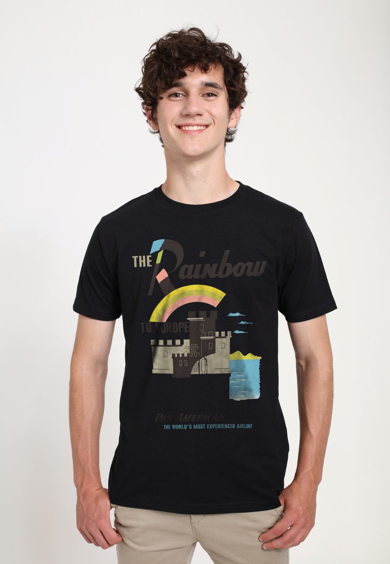 Svart bomullströja med en grafik av ett slott, regnbåge och text. Designen inkluderar färger som rosa, blå och grå.