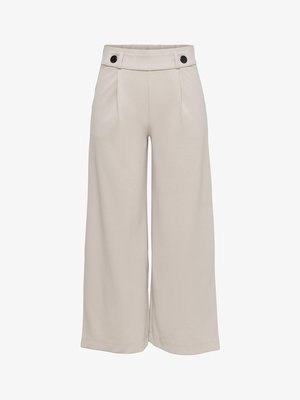 Pantalons larges beiges en tissu lisse, dotés d'une taille haute avec deux boutons noirs, de plis frontaux diagonaux et d'un ourlet propre.