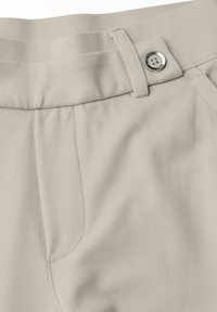 Pantalones color beige claro hechos de una tela suave y lisa. Cuentan con una cinturilla plana, costuras visibles, bolsillos laterales y un acento de botón metálico.