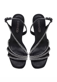 Schwarze Slingback-Absätze mit mehreren diagonalen Riemen, die mit silbernen Strasssteinen verziert sind. Glatte Ledertextur mit glänzender Oberfläche.