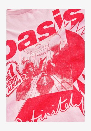 Svetlo roza majica s poudarjenim rdečim tiskom, ki vsebuje besedilo in ilustrirano sceno ljudi v prostoru z pohištvom in okrasnimi detajli.