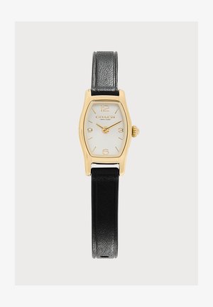 Reloj de pulsera Coach en tono dorado con esfera blanca, marcadores dorados y correa de cuero negra que muestra la hora 10:10.