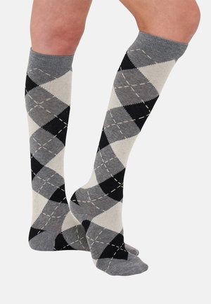 Calcetines hasta la rodilla en un patrón de rombos en gris, negro y crema, con una textura suave y formas de diamante contrastantes con detalles cosidos.