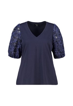 Donkerblauwe t-shirt met een v-hals en pofmouwen. Mouwen zijn gemaakt van een textuurstof in marineblauw met geborduurde sequinspatronen.
