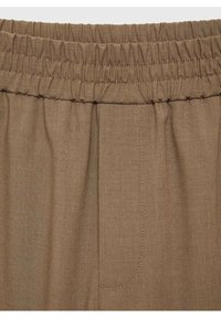 Tissu marron à texture lisse, doté d'une ceinture élastique, d'une poche latérale, de détails cousus et d'une coupe décontractée.