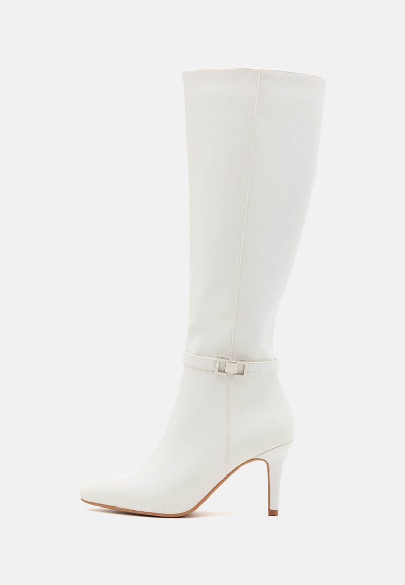 Bottes blanches jusqu'aux genoux en matériau synthétique lisse, avec un bout pointu, un talon haut et un accent de boucle argentée.
