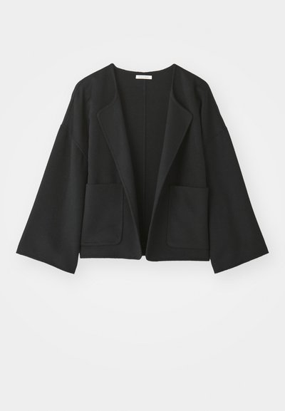 Jaqueta preta curta feita de tecido suave. Possui mangas largas, frente aberta e dois bolsos frontais. Design simples e limpo, sem fechos.