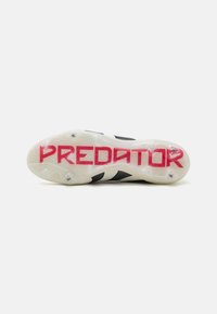 Black and white soccer cleat sole with clear rubber, featuring prominent red "PREDATOR" text, and three studded traction points.
