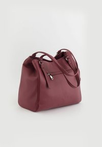 Bolso de piel burdeos con superficie texturizada, doble asa superior y bolsillo frontal con cremallera. Forma redondeada, diseño casual.