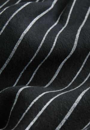 Sort stof med hvide horisontale striber og en tekstureret overflade. Striberne er jævnt fordelte og skaber et diskret mønster på materialet.