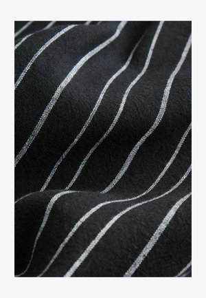 Melns audums ar baltām horizontālām svītrām un teksturētu virsmu. Svītras ir vienmērīgi izvietotas, radot smalku rakstu pa visu materiālu.