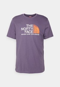 Fialové tričko vyrobené z bavlny, krátké rukávy a kulatý výstřih. Obsahuje bílé a oranžové grafické logo s nápisem "THE NORTH FACE."