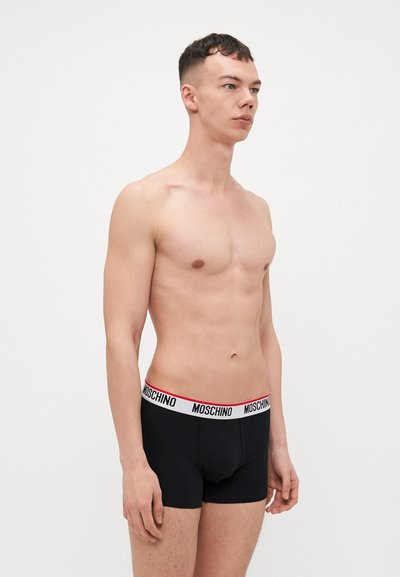 Mustat boxerit valkoisella ja punaisella Moschino-logo vyötärönauhalla, joissa on tiukka istuvuus ja sileä rakenne.