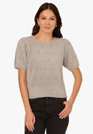 Light gray short-sleeve sweater made of soft, textured fabric with a slightly cropped fit. Decorated with scattered pearl-like accents.