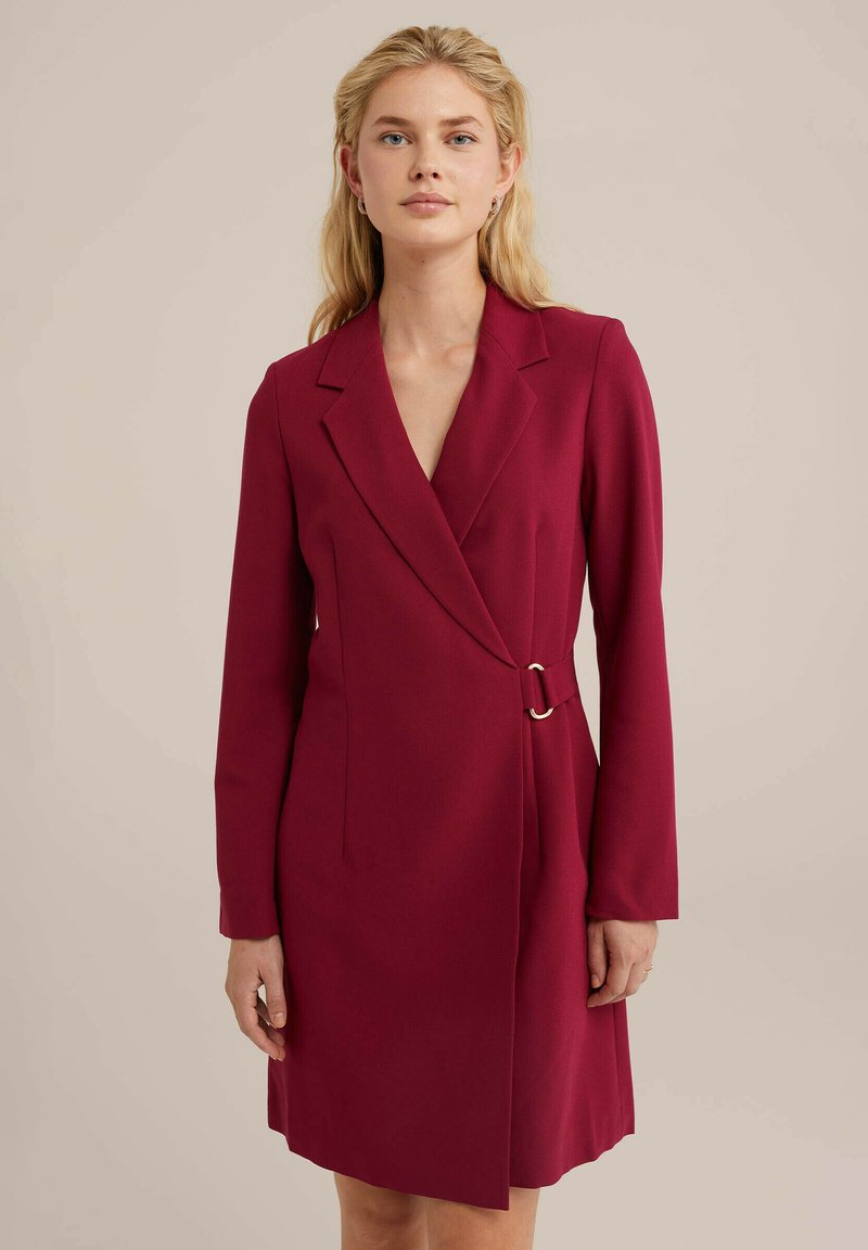 Robe portefeuille bordeaux en tissu structuré, avec des manches longues, un décolleté en V et un accent en métal doré à la taille.
